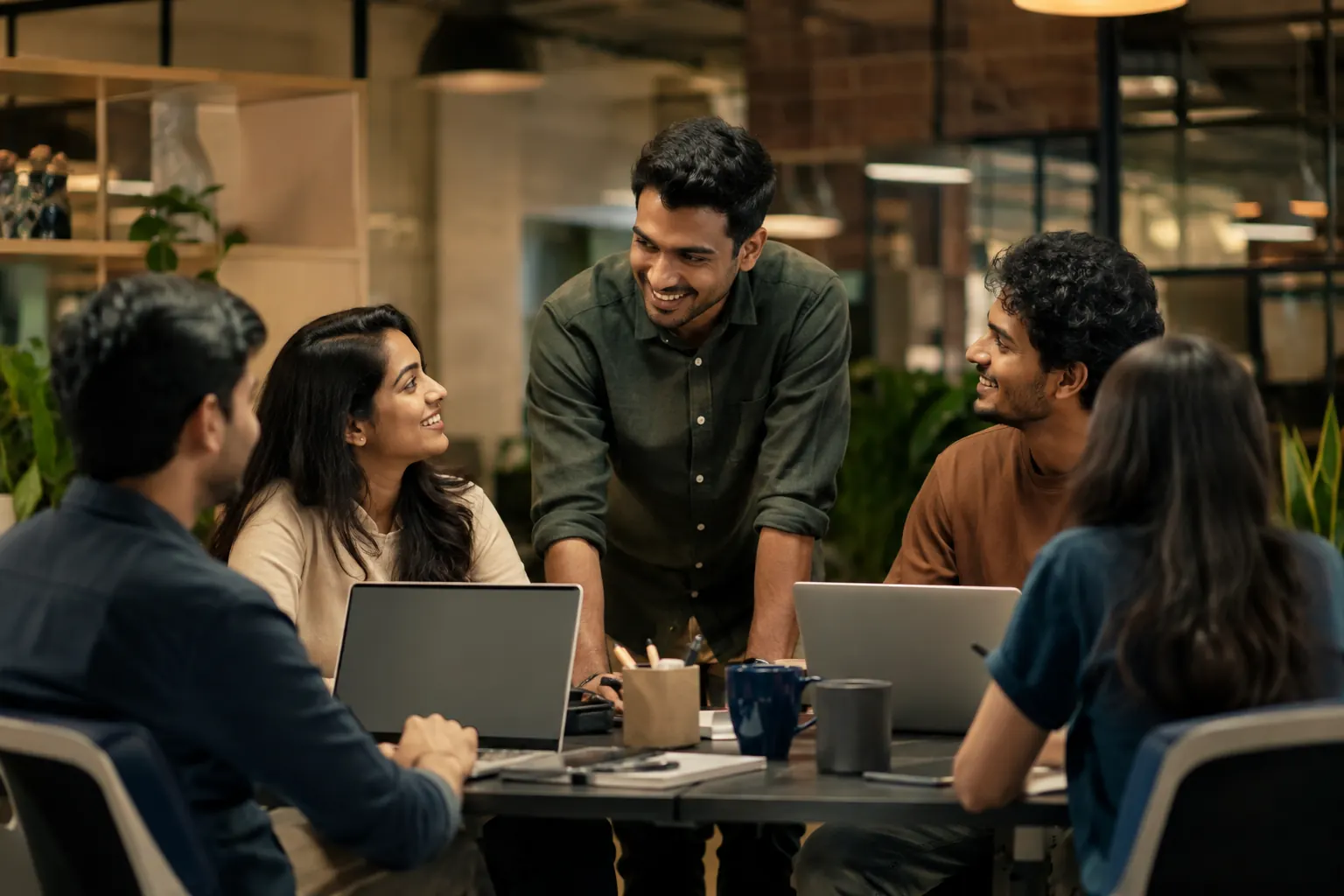 A hiring team reviewing candidates together around a laptop